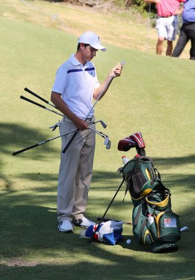 Ryan Ruffels gets his clubs ready at practice. 