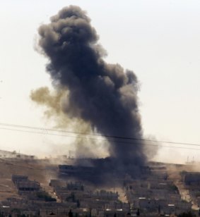 Under fire: A shell lands in Kobane as fighting intensifies.