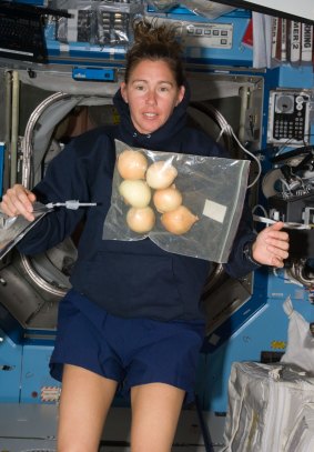 Former NASA astronaut Dr Sandra Magnus pictured with a bag of fresh onions floating freely in the Destiny laboratory of the International Space Station in 2008.