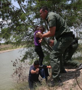 US Border Patrol agents help minors from El Salvador after they crossed the Rio Grande illegally into the United States in July  2014 in Mission, Texas.