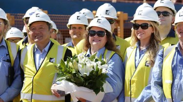 Gina and Ginia Reinhart (centre) with Roy Hill chief executive Barry Fitzgerald sa the first shipment of iron ore from Roy Hill Mine is prepared for shipments from Port Hedland, WA on December 10.