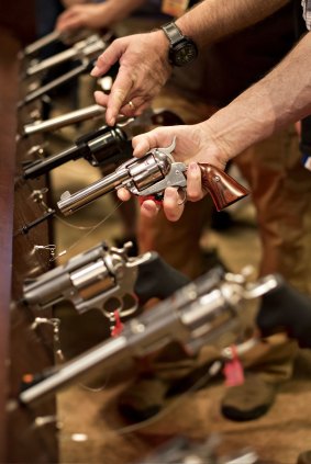 An attendee handles a revolver in the Sturm, Ruger & Co., Inc. booth at the 144th National Rifle Association annual meeting in Nashville.