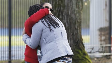 A student is reunited with a family member outside the Rosemary Anderson High School in Portland, Oregon.