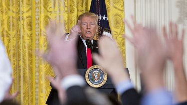 U.S. President Donald Trump takes a question from members of the media during a news conference.