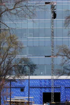 Yellow tape surrounds the piece of scaffolding that fell to the ground as a large section of framework hangs near shattered windows of the Charter Square building.