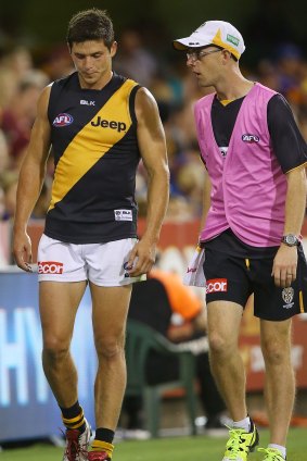 Richmond's Chris Knights leaves the field injured during the match against the Brisbane Lions.