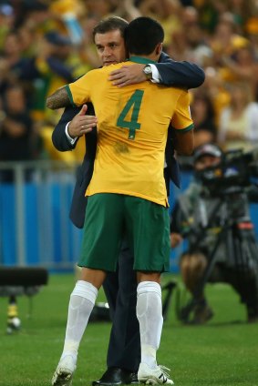 Well done: Ange Postecoglou embraces Tim Cahill.