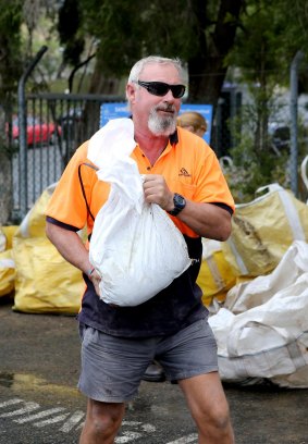 Mark Finlay collects sandbags for his Algester home ahead of the expected downpour.