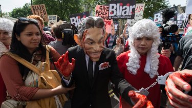 A demonstrator dressed as Tony Blair, with painted red hands and in handcuffs, protests Britain's involvement in the Iraq war in London on Wednesday.