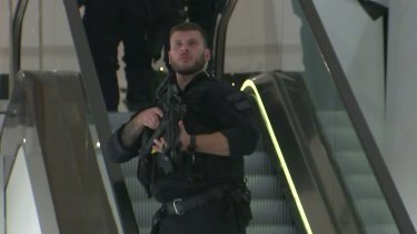 An armed police office patrols a department store on Oxford Street after reports of a shooting.