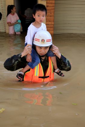 Soldiers evacuate trapped people from a flood-hit area in Rongshui, China.  