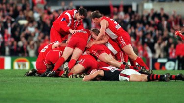 John Orchard (standing on the left) celebrates with players after Tony Lockett put the Swans into the 1996 grand final.