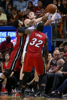 Trapped: Australian forward Joe Ingles of the Utah Jazz is defended by Udonis Haslem #40 and James Ennis #32 of the Miami Heat.