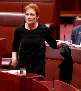 Senator Pauline Hanson pulls off the garment.