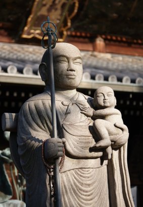 A statue welcomes pilgrims to his shrine.