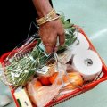 Supermarket shopper with basket of groceries.