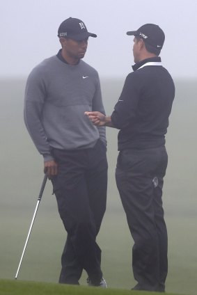 Tiger Woods talks to swing instructor Chris Como.