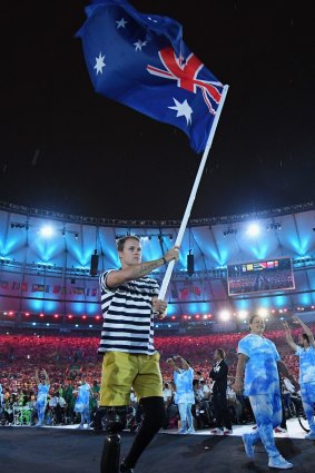 Gold medalist Curtis McGrath carries the flag for Australia during the closing ceremony of the 2016 Paralympic games in Rio.
