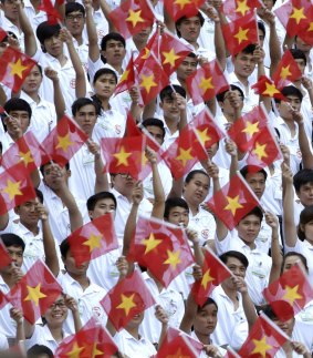Performers wave Vietnamese national flags during a parade celebrating the 40th anniversary of the end of the Vietnam War.  Vietnam's economy is growing by around 6 per cent every year.