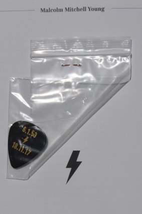 A guitar pick inside the order of service program for Malcolm Young's funeral.