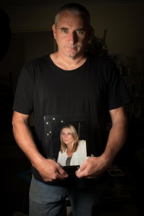 Jamie Hare holding a picture of his partner Linda who died in 2010.