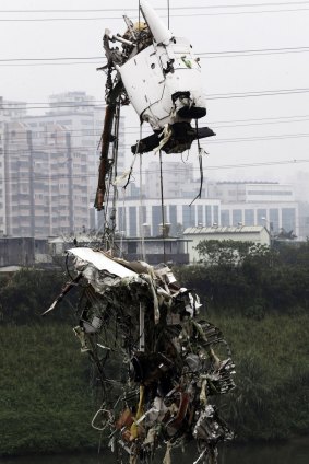 Part of the wreckage of TransAsia Airways plane Flight GE235 is lifted after it crash landed into a river. 