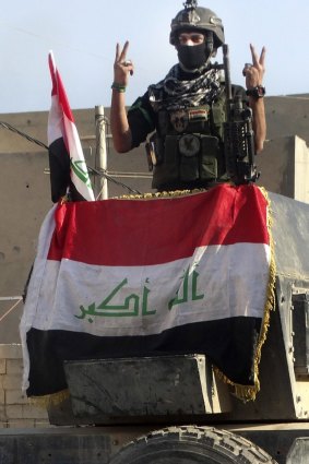 An Iraqi soldier flashes the victory sign after entering the government complex in central Ramadi.