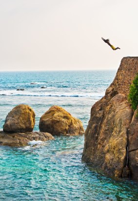 A man hurls himself from a cliff near Galle.