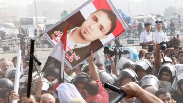 Egyptian anti-Mubarak protesters, carrying a photo of a killed protester, clash with riot police in Cairo in 2011. 