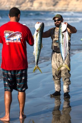 Reeling 'em in from the beach.
