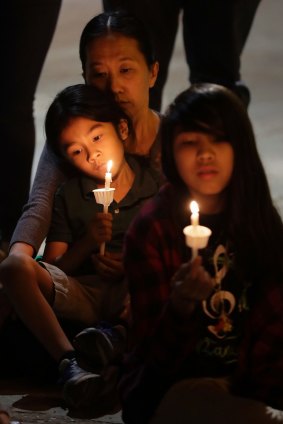 Yon Hui Bell holds her son, Emilio Rafael, as they join community activists in front of San Fernando Cathedral in San Antonio, Texas, for a vigil on the eve of Donald Trump's inauguration.