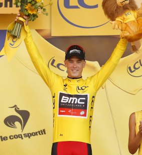 Australia's Rohan Dennis, wearing the overall leader's yellow jersey, celebrates on the podium of the first stage of the Tour de France.