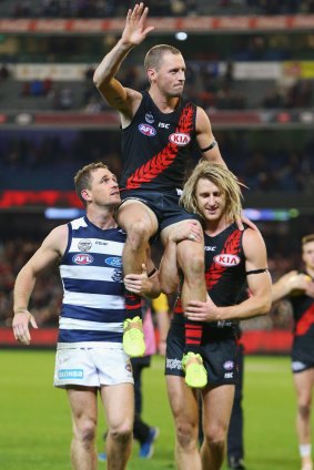 Bomber James Kelly is chaired off the ground by former teammate Joel Selwood and Dyson Heppell after Kelly's 300th match.