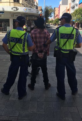 Police handcuff a protester who allegedly confronted a UPF speaker.
