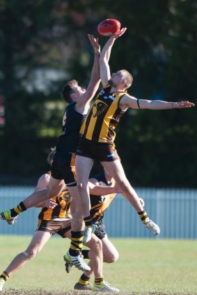 Tigers' Justin Galloway and Hawks' Ben Sherring go up in the ruck.