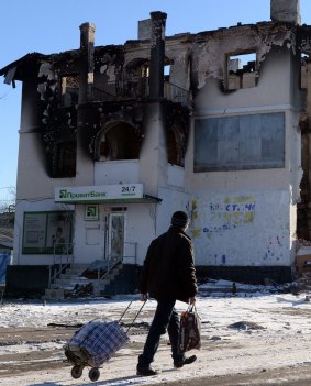 A man walks past a damaged building in Uglegorsk, six kilometres south-west of Debaltseve.