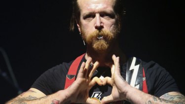 Jesse Hughes, frontman of California rock band Eagles of Death Metal, makes a heart sign as the band performs at the Olympia Concert Hall in Paris on Tuesday.
