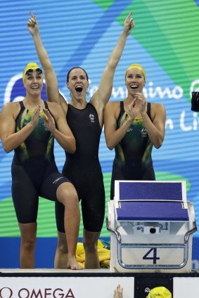 Australia's Emma McKeon, Brittany Elmslie and Bronte Campbell celebrate as Cate Campbell, bottom, finishes the women's 4x100-meter freestyle final setting a new world record.