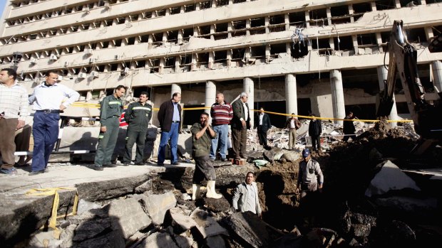 Deadly attack: Workers at the crater made by the bomb outside the Cairo police headquarters.