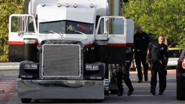 San Antonio police officers investigate the semi trailer where the gruesome discovery was made.