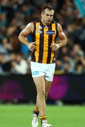 Hawthorn defender Brian Lake leaves the field with an injury. 