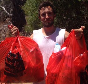 Ben Catley  with two of the seven bags of rubbish collected from Blackwall Reach on the Swan River.