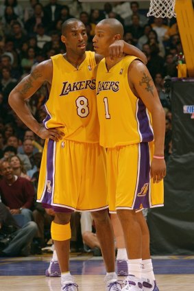 Kobe Bryant talks with Caron Butler during a Los Angeles Lakers game in 2004.