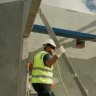Workers pulling together pre-fabricated building parts.