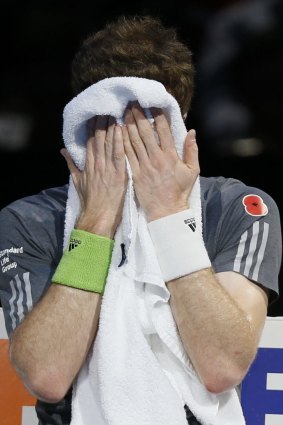 Andy Murray holds his face in a towel during a break.