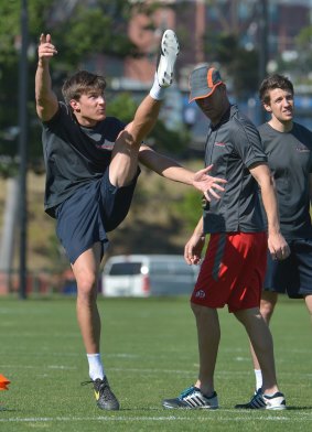 Josh Growden learns to kick the American way with Nathan Chapman (in red shorts).