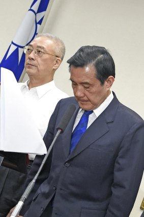 Taiwan President Ma Ying-jeou, right, bows in apology to supporters at the headquarters of the ruling Kuomintang after the election results.