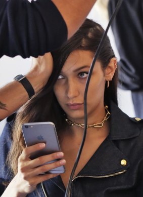 Model Bella Hadid has her hair styled backstage before the Michael Kors Spring 2017 collection.