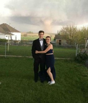 Charlie Bator and Ali Jolie Marintzer pose for a photo as a tornado looms near Wray, Colorado. 
