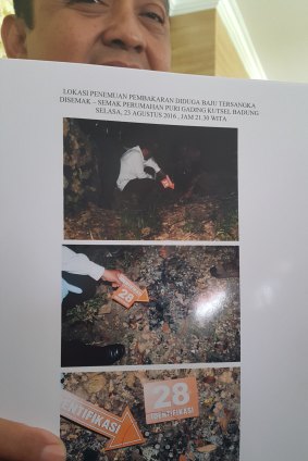 Denpasar police chief Hadi Purnomo with photos of the burned clothing remains found in a Jimbaran housing estate.  